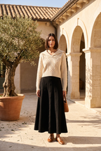 Beige sweater and black skirt on model