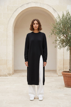 Muse black knit dress in a limestone courtyard