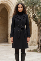 Sélène black belted coat in a limestone courtyard