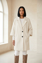 Héritage ivory coat with two buttons in a stone gallery