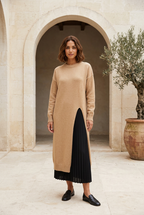 Muse beige knit dress in a limestone courtyard