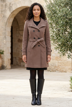 Sélène brown belted coat in a limestone courtyard
