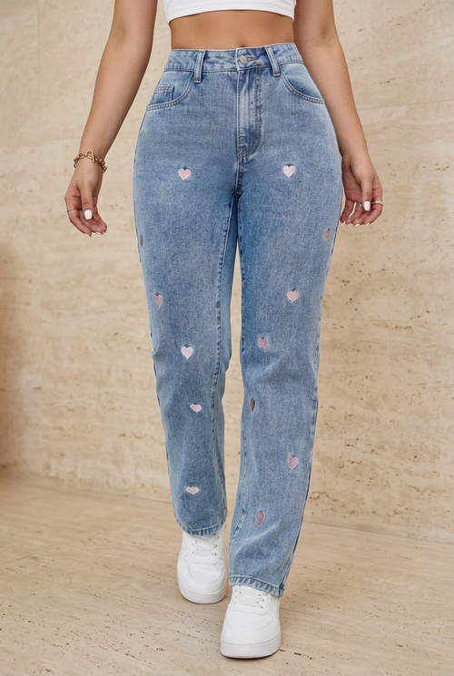 Embroidered blue jeans front view against beige stone background